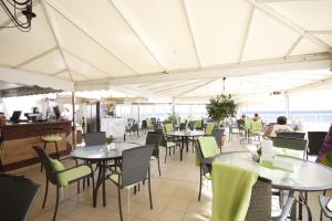 een restaurant met tafels en stoelen en mensen die er zitten bij Atlantic Beach Club in Playa del Inglés
