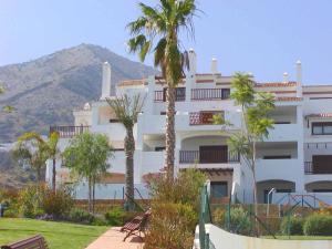 duży biały budynek z palmami przed nim w obiekcie 2 Bedroom Apartments on Private Gated Development w mieście Mijas