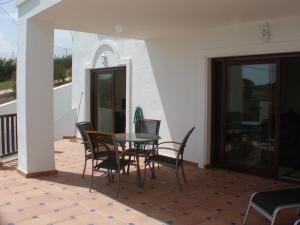 taras ze stołem i krzesłami na balkonie w obiekcie 2 Bedroom Apartments on Private Gated Development w mieście Mijas