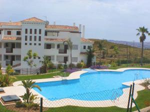 duży dom z basenem przed nim w obiekcie 2 Bedroom Apartments on Private Gated Development w mieście Mijas