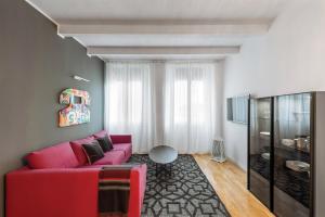 ein Wohnzimmer mit einem roten Sofa und einem TV in der Unterkunft Residence le Porte in Bologna
