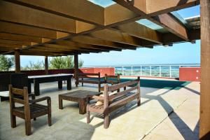 a patio with benches and a table and a piano at De Rose Praia Hotel in Torres