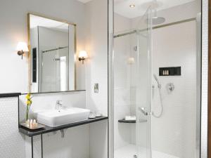 bagno con lavandino e doccia in vetro di Newpark Hotel a Kilkenny