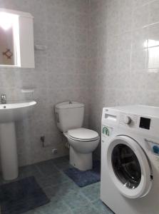 a bathroom with a toilet and a washing machine at Leonidio Climb2red home in Leonidio
