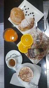 stół z pączkami i filiżankami kawy i pomarańczy w obiekcie Bed & Breakfast San Marco w mieście Tarent