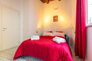 ナポリにあるLa Pazziella Flatのベッドルーム1室(赤いベッド1台、タオル2枚付)