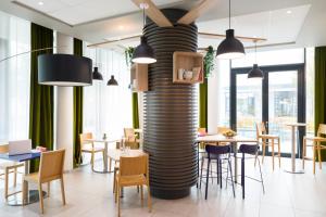 a room with tables and chairs and a large column at Aparthotel Adagio access München City Olympiapark in Munich