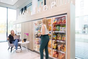 a woman is standing in front of a refrigerator at Aparthotel Adagio access München City Olympiapark in Munich