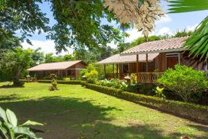 a house in a yard with a grass yard sidx sidx sidx at Escape Caribeño in Puerto Viejo