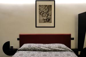 a bedroom with a bed and a picture on the wall at The Boutique Napoli Suite in Naples