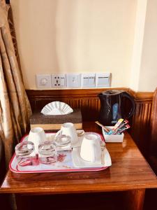 - un plateau avec des tasses et de la vaisselle sur une table en bois dans l'établissement Mother's Home Hotel, à Nyaung Shwe