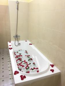 a bathroom with a tub with roses on it at Mother's Home Hotel in Nyaung Shwe