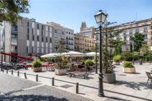 a street light in a city with tables and chairs at Slow Suites Augusto in Madrid