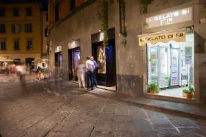 due persone in piedi fuori da un negozio in una strada di Apartments Lorenzo&Lorenzo a Firenze
