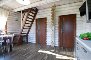 a porch of a log cabin with a wooden staircase at klub Karino 2 in Mikołajki