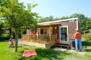 a man standing in front of a tiny house at Camping Capfun La Bretèche in Les Épesses