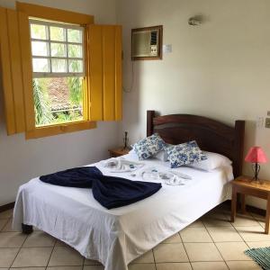 a bed in a bedroom with a window at Pousada Fortaleza in Paraty