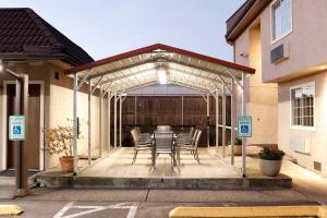 a patio with a table and chairs under a pergola at Best Lynnwood Inn in Lynnwood