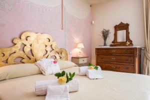 a bedroom with a large white bed with towels and a dresser at Molino Della Lodola in Rapolano Terme +25 photos