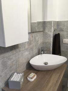 a bathroom with a white sink and a mirror at La casa in piazza in Modica