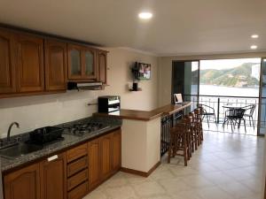 a kitchen with wooden cabinets and a view of a balcony at EDIFICO EL PEÑON DEL RODADERO APTO. 405A in Santa Marta