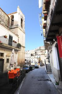 an alley with an orange table and buildings at La casa in piazza in Modica