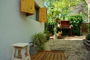 un patio con una mesa y una silla junto a un edificio en La Casa de Huéspedes, en Santa Teresita