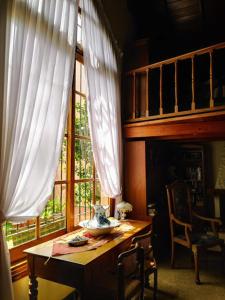 Habitación con mesa de madera y ventana. en Bed & breakfast Familia San Martín en Vicente López