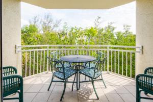 eine Terrasse mit einem Tisch und Stühlen auf dem Balkon in der Unterkunft Sunrise Suites Saint Lucia Suite #201 in Key West