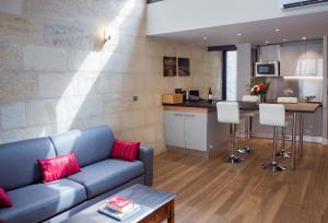 a living room with a couch and a kitchen at Appartement Climatisé avec Rooftop en Hypercentre in Bordeaux