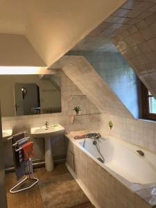 un ampio bagno con vasca e lavandino di Maison Normande ad Auberville