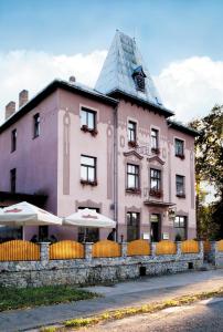 un edificio rosa con techo en una calle en Hotel Grand, en Řevnice
