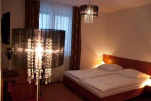 1 dormitorio con cama y lámpara de araña en Willa Agnieszka en Kazimierz Dolny