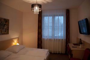 a bedroom with a bed and a window with a chandelier at Willa Agnieszka in Kazimierz Dolny