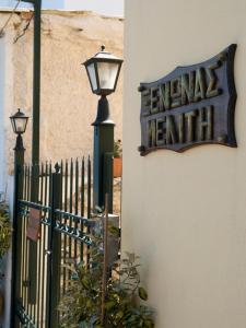 una señal y una luz de la calle junto a una valla en Meliti Guesthouse, en Akráta