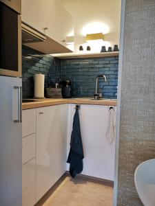 una cocina con armarios blancos y fregadero en RhePi-Apartment, en Essen