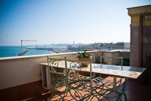 un tavolo e sedie su un balcone con vista sull'oceano di san nicola d'amare a Bari