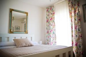 1 dormitorio con cama con espejo y ventana en san nicola d'amare en Bari