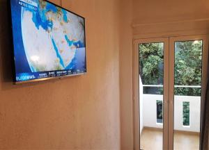 einen Flachbild-TV, der an einer Wand neben einer Tür hängt in der Unterkunft Floral Hotel in Hersonissos