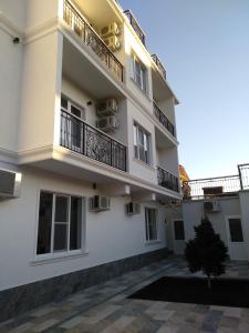 a white building with balconies and a courtyard at Blue Marine Hotel in Adler