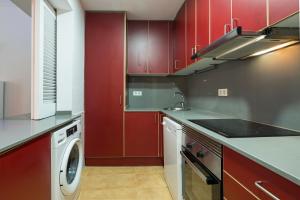バルセロナにあるSibsBcn COLISEUM - Cozy and Centralのキッチン(赤いキャビネット、洗濯機付)