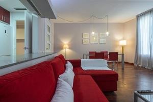 バルセロナにあるSibsBcn COLISEUM - Cozy and Centralのリビングルーム(赤いソファ付)、ダイニングルーム