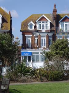 a large house with a balcony on top of it at Breakers Bed and Breakfast in Eastbourne