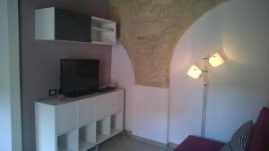 un soggiorno con una TV a parete di Antica Dimora I Dragoni a Cagliari