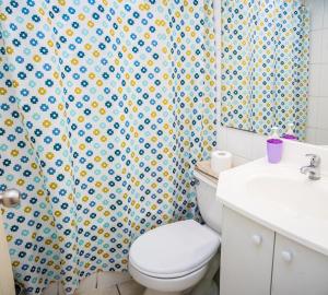 a bathroom with a toilet and a shower curtain at Zenteno Apartments in Santiago +43 photos