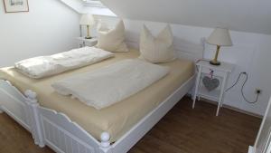 1 dormitorio con 2 camas con sábanas y almohadas blancas en Augusta-Refugium en Augsburg