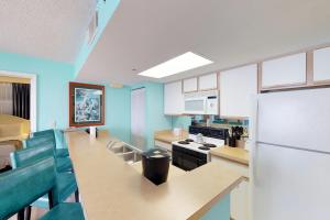 cocina con paredes azules y nevera blanca en Sunrise Suites Catalina Suite #311, en Key West