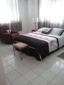 a bedroom with a large bed and a chair at Ocean Dreams in Aguada