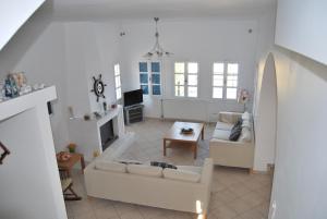 a living room with two white couches and a tv at BAY VIEW HOUSE in Megas Gialos - Nites