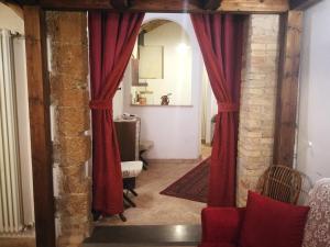 uma sala de estar com cortinas vermelhas num quarto em Appartamento La Loggia em Orvieto